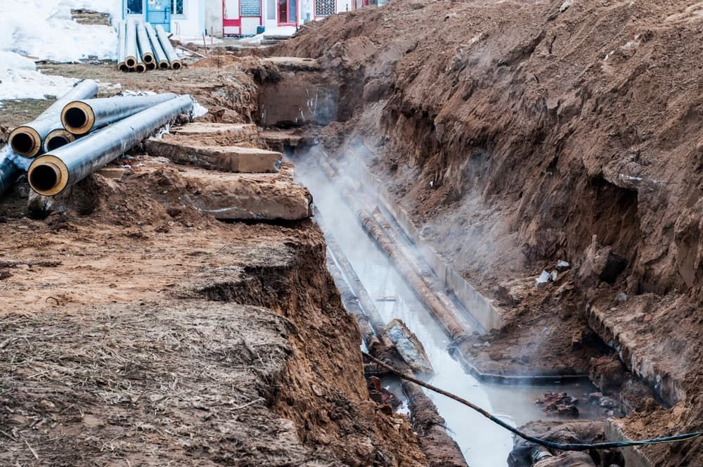 A Pipe Is Coming Out Of The Ground In A Trench — Nudges Plumbing In Dubbo, NSW