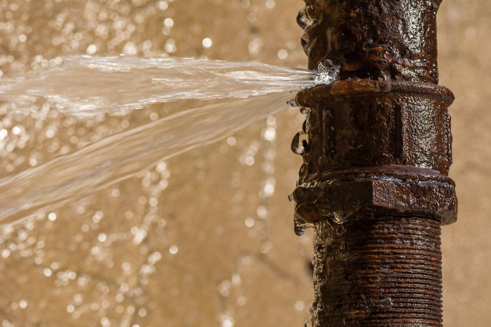 A Rusty Pipe Is Leaking Water And Water Is Coming Out Of It — Nudges Plumbing In Nyngan, NSW