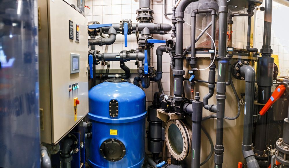 A Room Filled With Lots Of Pipes And A Blue Tank — Nudges Plumbing In Nyngan, NSW