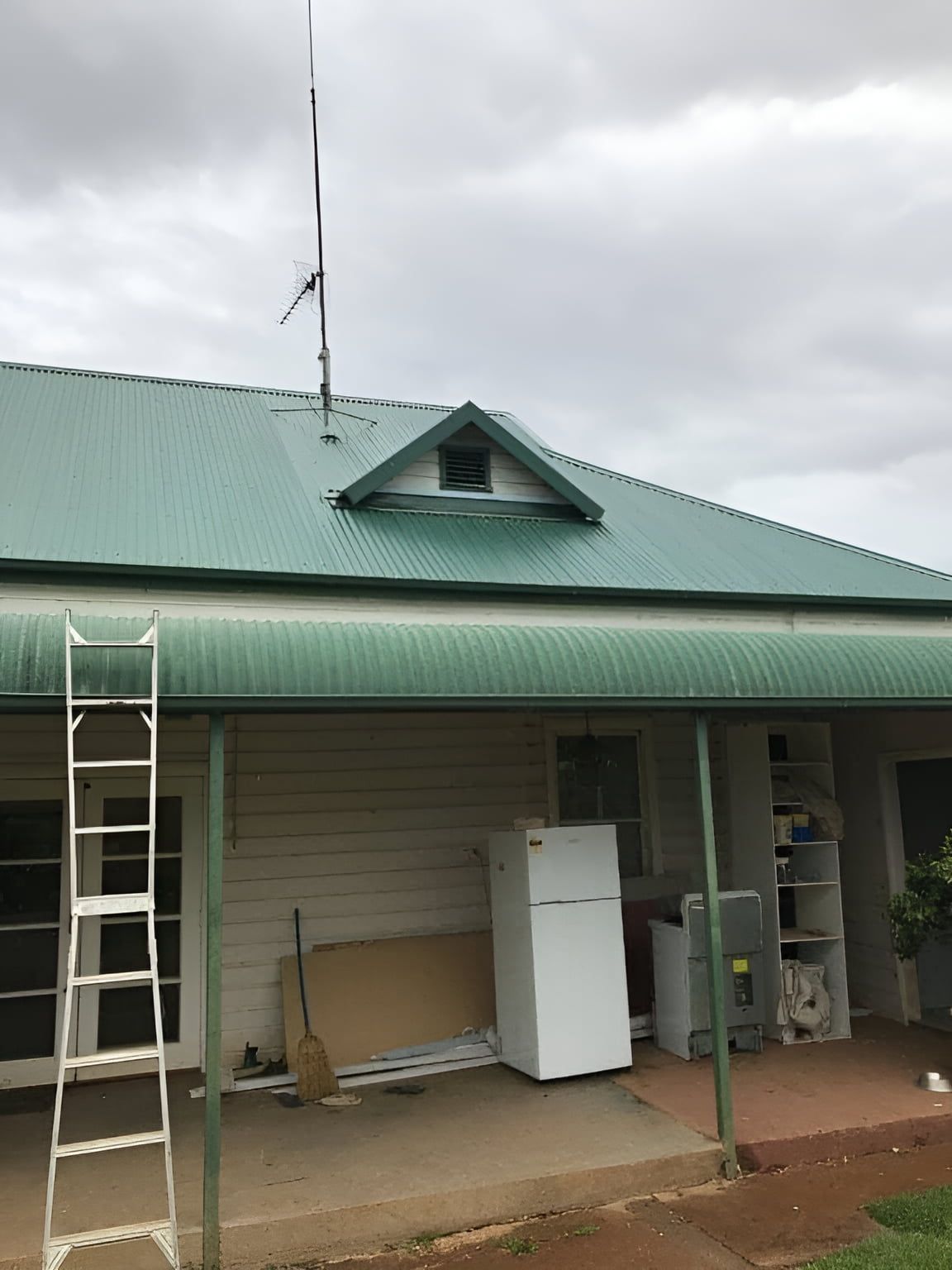 A House With A Green Roof And A White Refrigerator — Nudges Plumbing In Dubbo, NSW