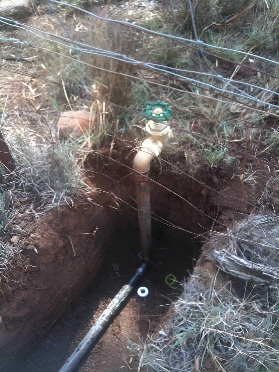 A Faucet With A Green Handle Is In A Hole In The Ground — Nudges Plumbing In Nyngan, NSW