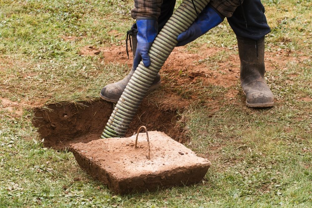 A Person Is Pumping A Hose Into A Hole In The Ground — Nudges Plumbing In Nyngan, NSW