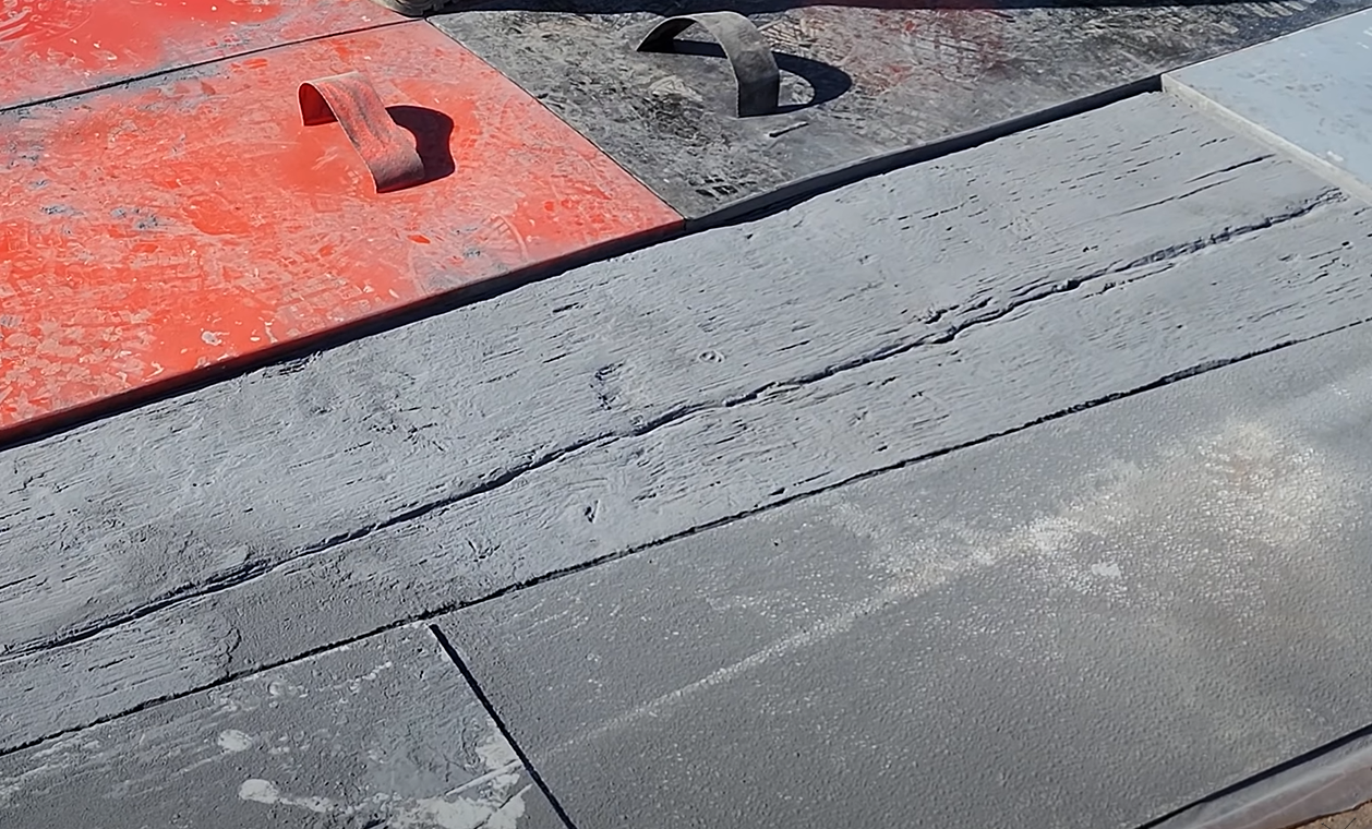 Concrete contractor stamping concrete to look like rustic barnwood