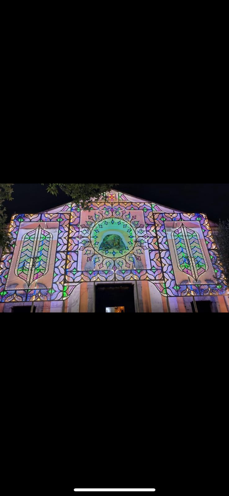 Un grande edificio con molte luci accese di notte.