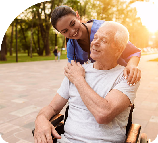 A woman is putting her arm around an older man in a wheelchair.