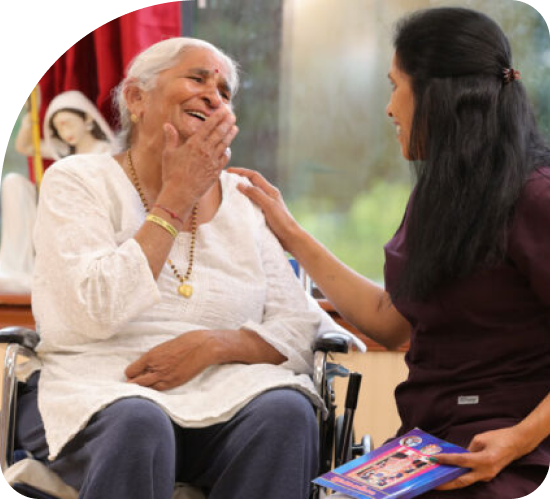 An elderly woman in a wheelchair is being comforted by a nurse