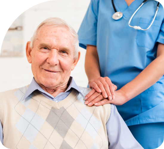 A nurse is holding the hand of an elderly man in a wheelchair.