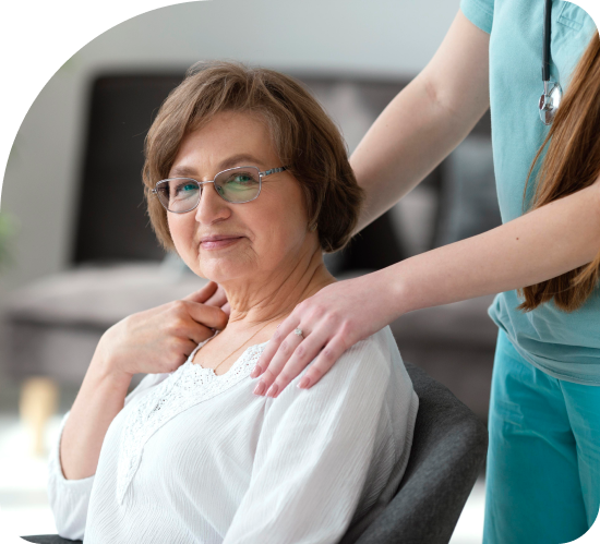 A woman is sitting in a chair with a nurse standing next to her.