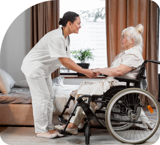 A nurse is shaking hands with an elderly woman in a wheelchair.