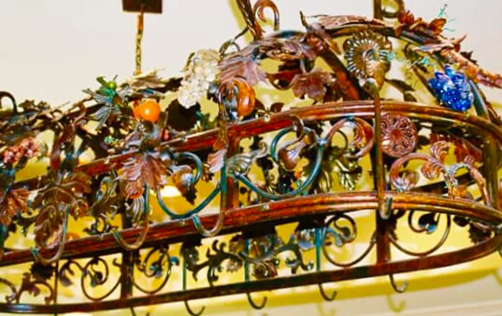 Ornate metal kitchen rack with leaf and fruit details.