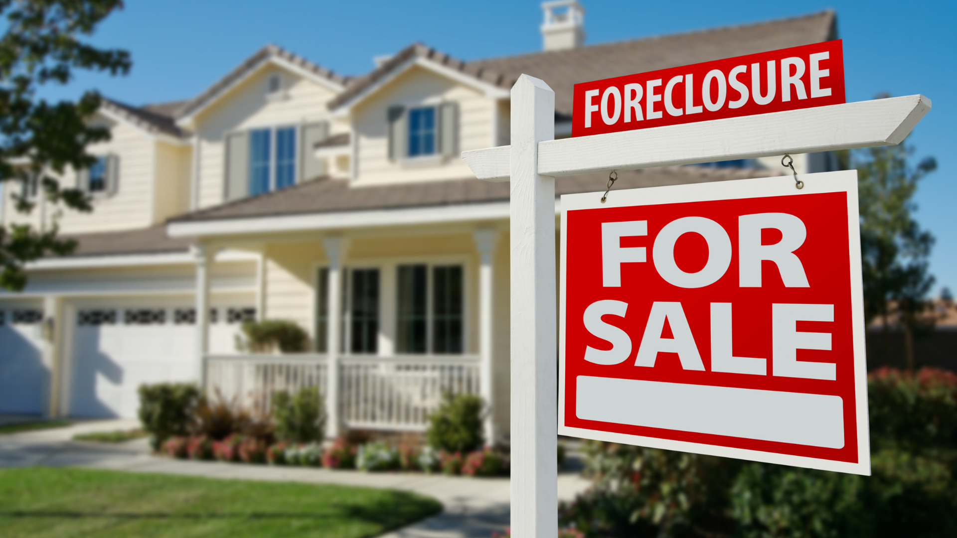 House for sale with foreclosure signs in front of a suburban home