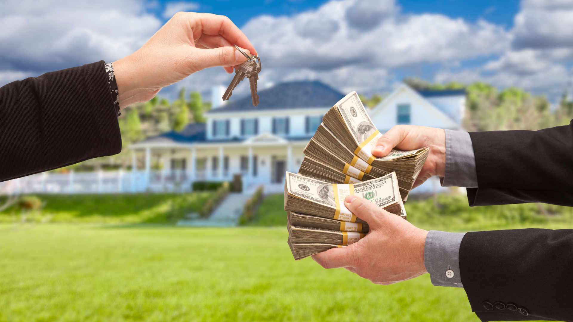 Hands exchanging house keys and cash in front of a suburban home