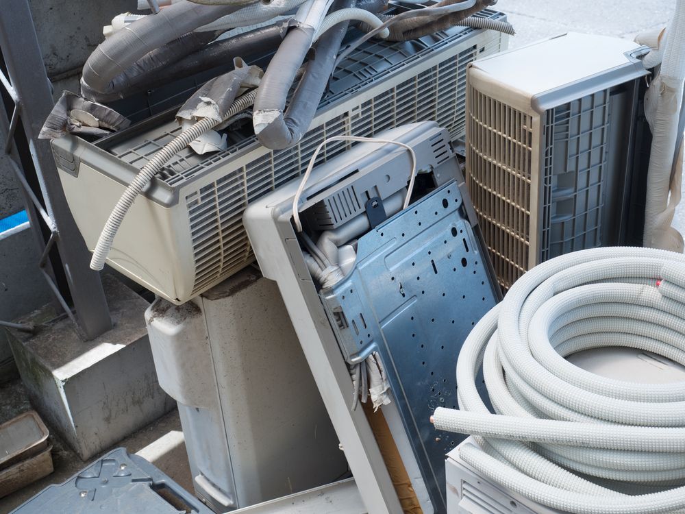 A Bunch Of Old Air Conditioners Are Sitting On Top Of Each Other On The Ground — Tweed Byron Recycling In Tweed Heads, NSW