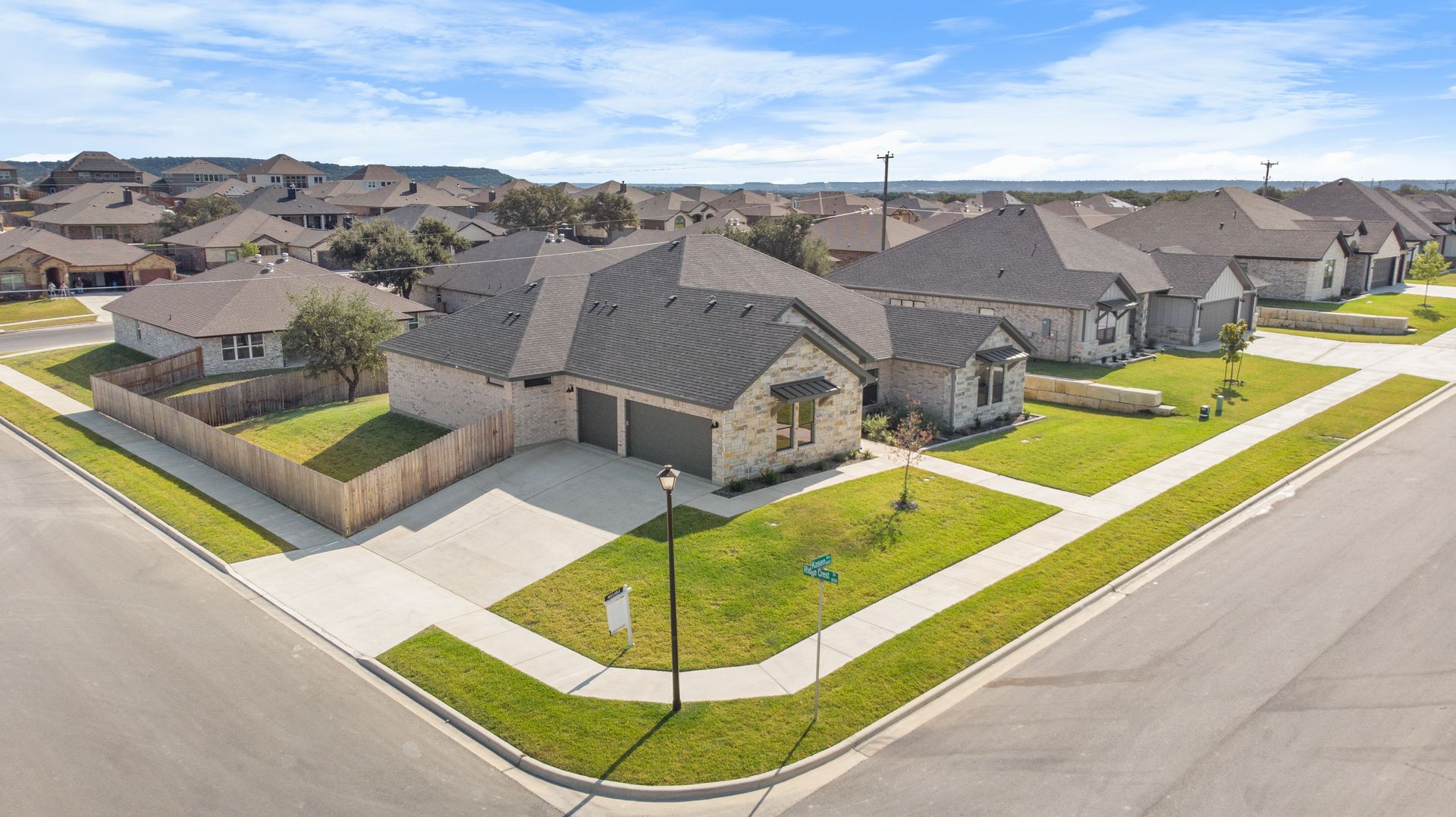 Residential neighborhood with houses on a sunny day; a two-car garage home is on a corner lot.