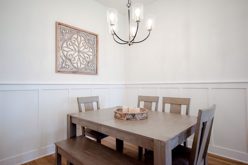 Dining room with a wooden table, chairs, and a decorative wall art.