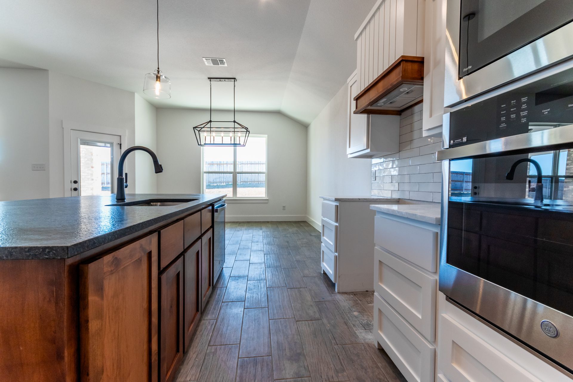 Kitchen with dark wood island, white cabinets, and stainless steel appliances.