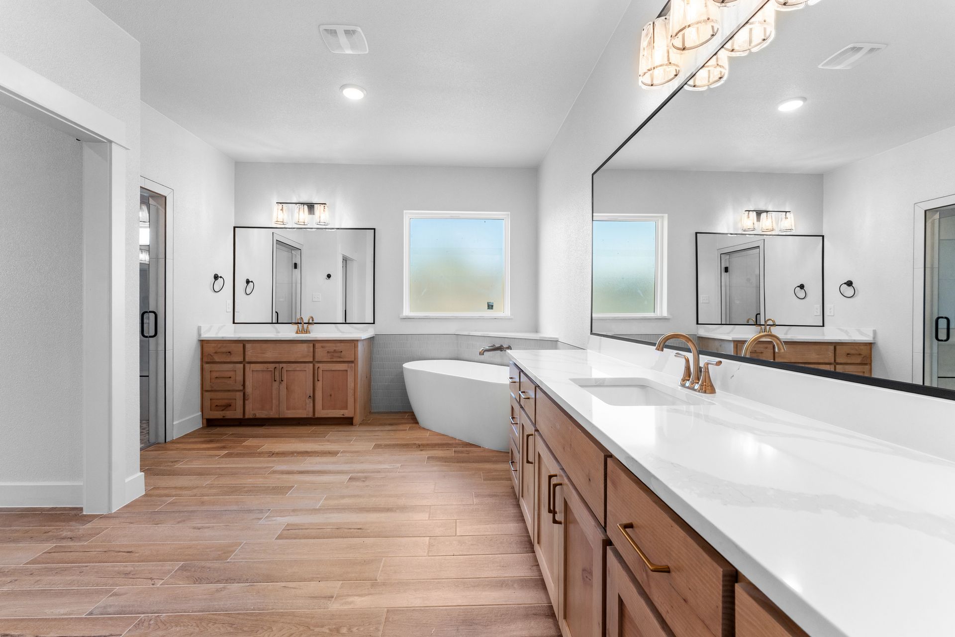 Spacious bathroom with wood cabinets, white countertops, and a large mirror.