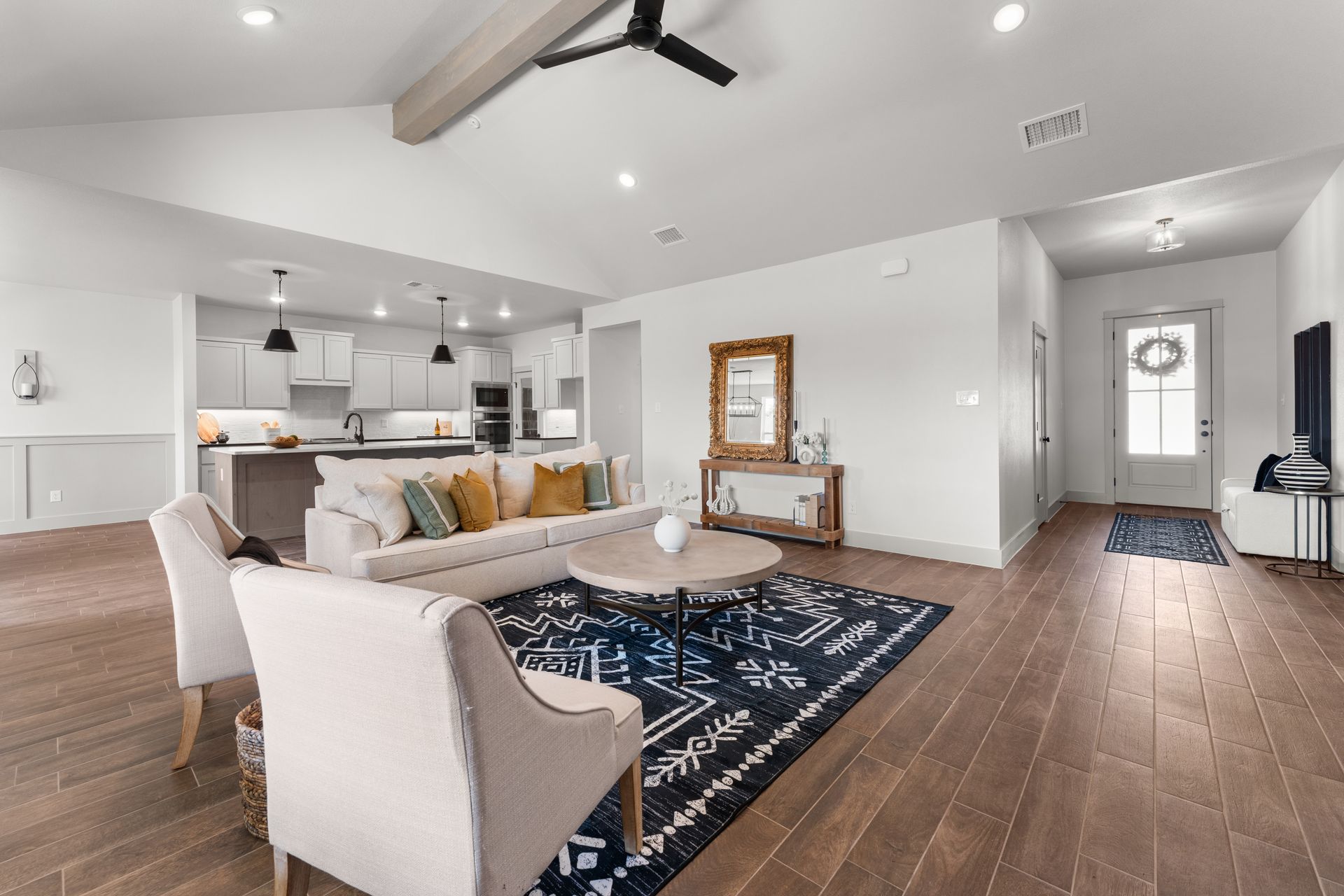 Spacious, modern living room with hardwood floors, open kitchen, and neutral color palette.