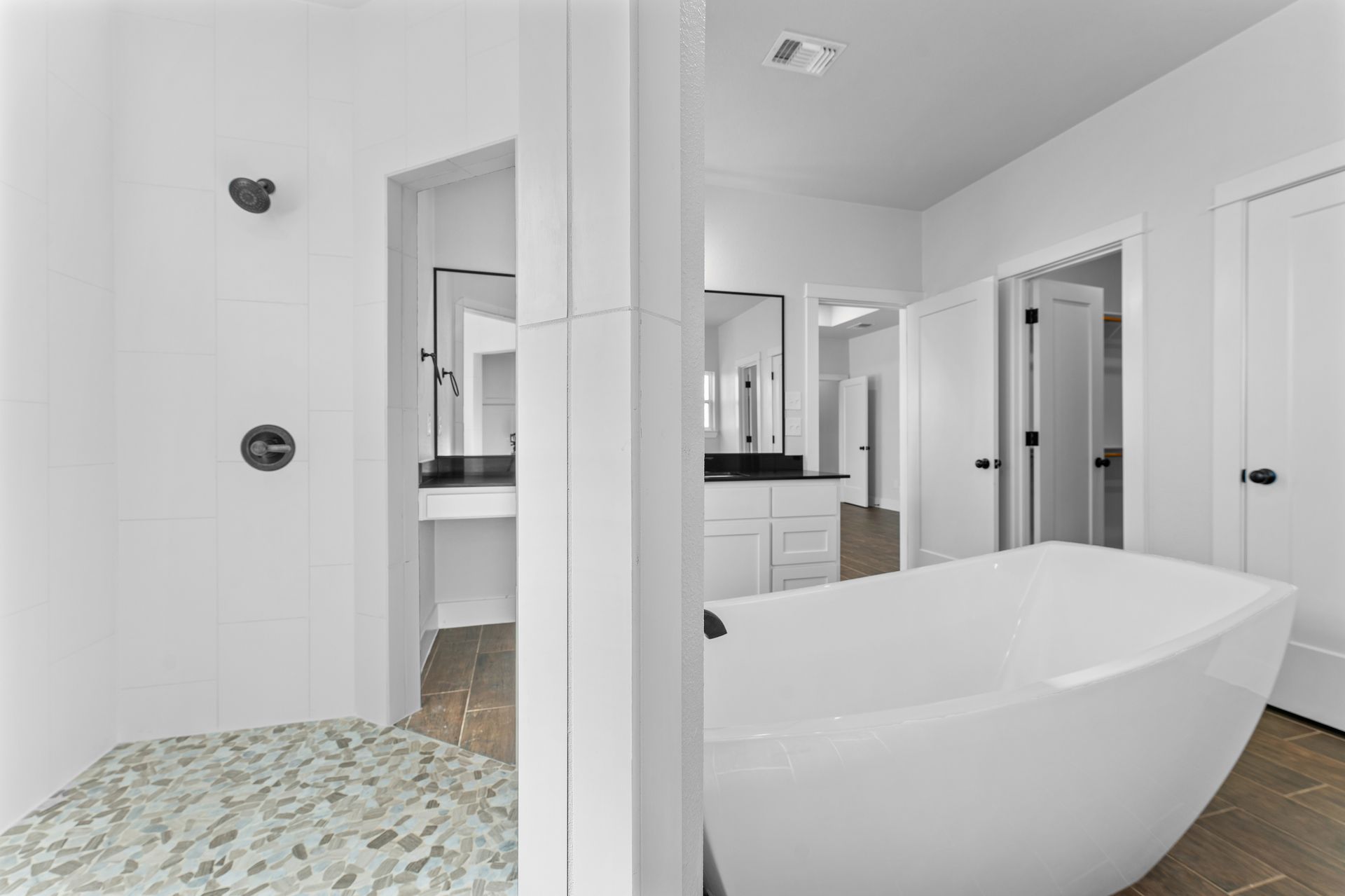 Modern white bathroom with a tub, shower, and vanity area.