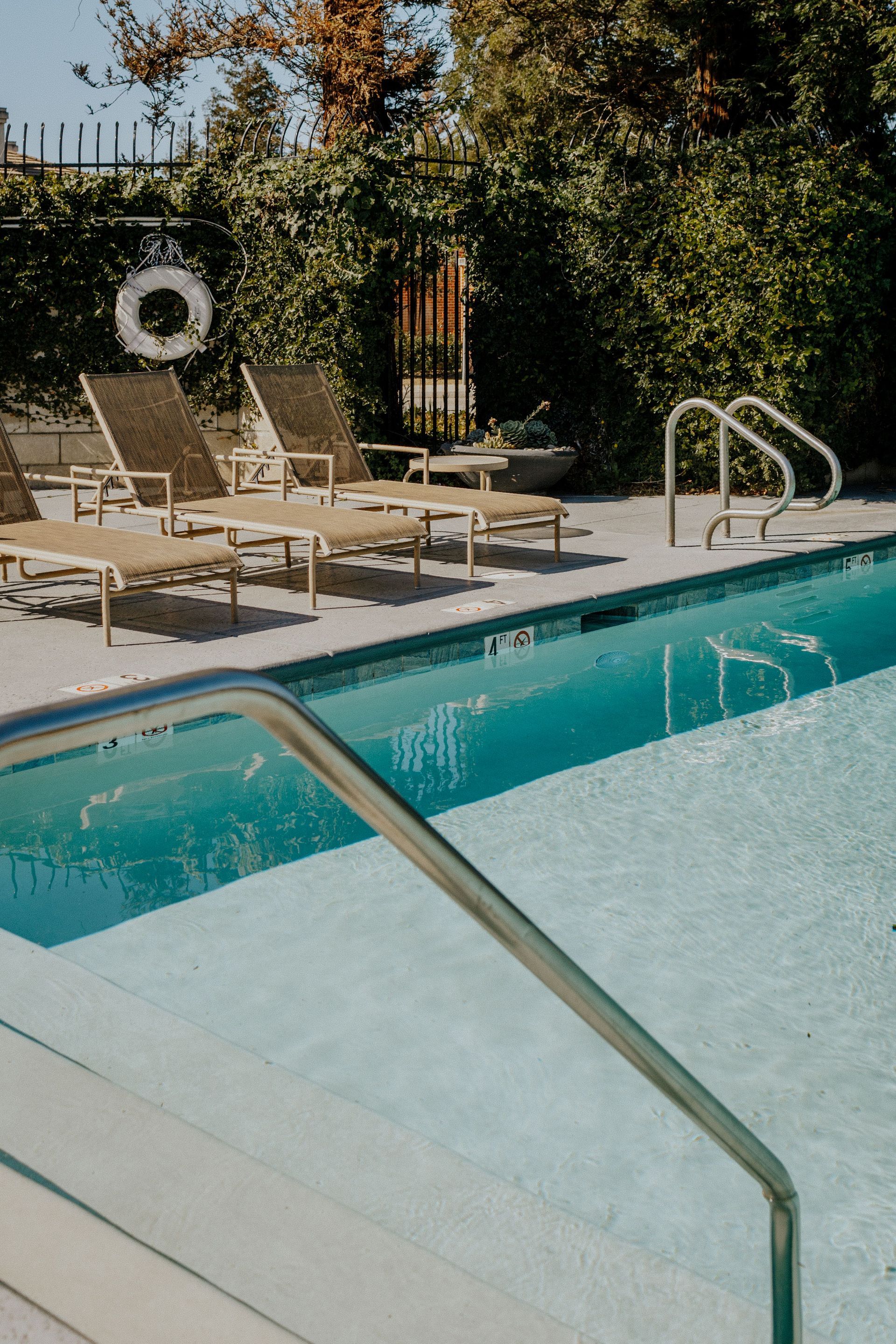 A large swimming pool with umbrellas and chairs around it