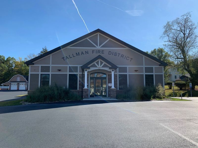 Tallman Fire District building with a dark roof and a paved parking lot on a sunny day.
