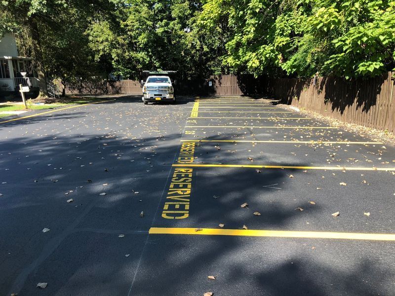 Parking lot with yellow reserved parking space markings and a vehicle parked in the back.