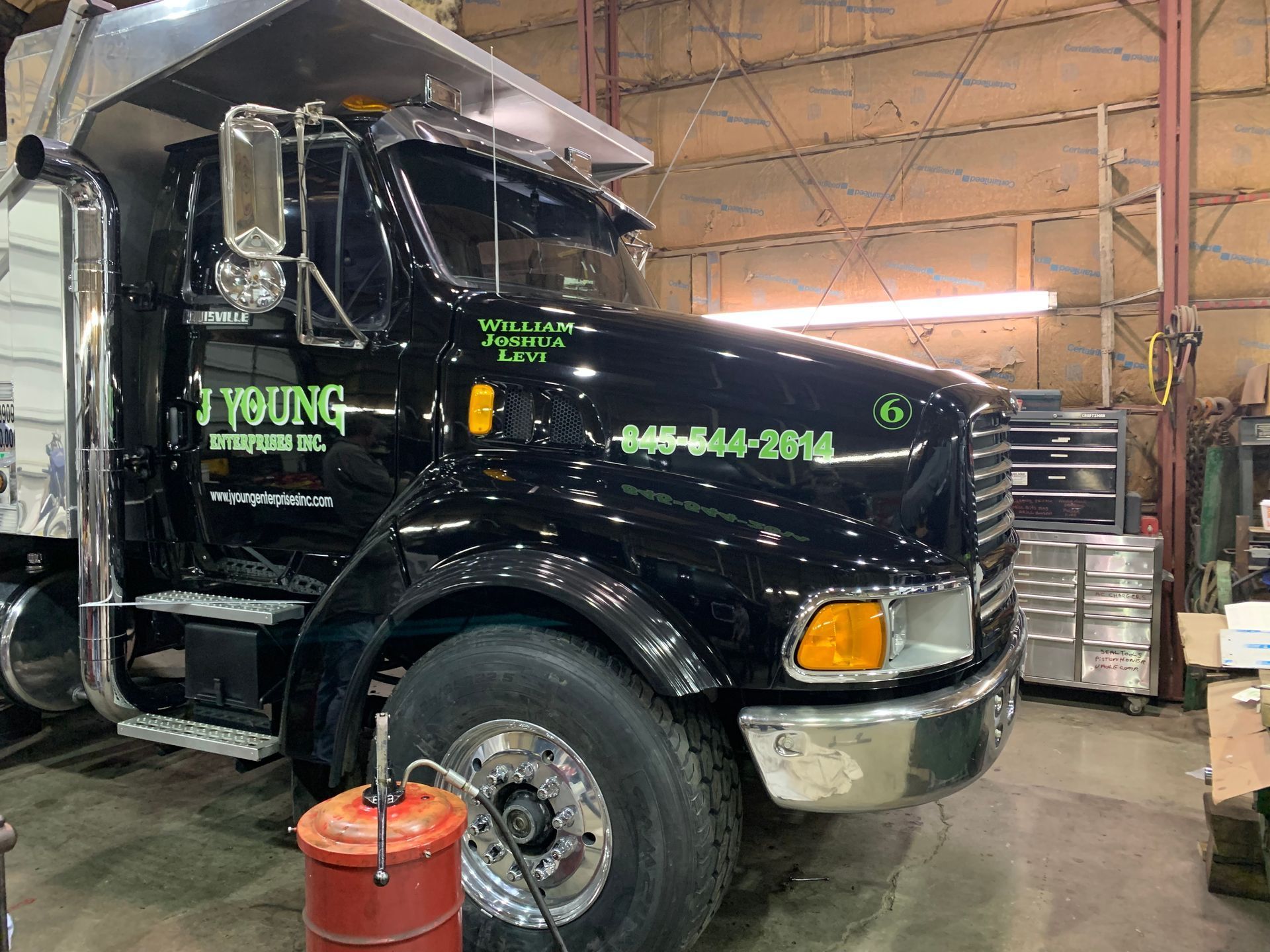 Black dump truck in a garage; chrome details, 