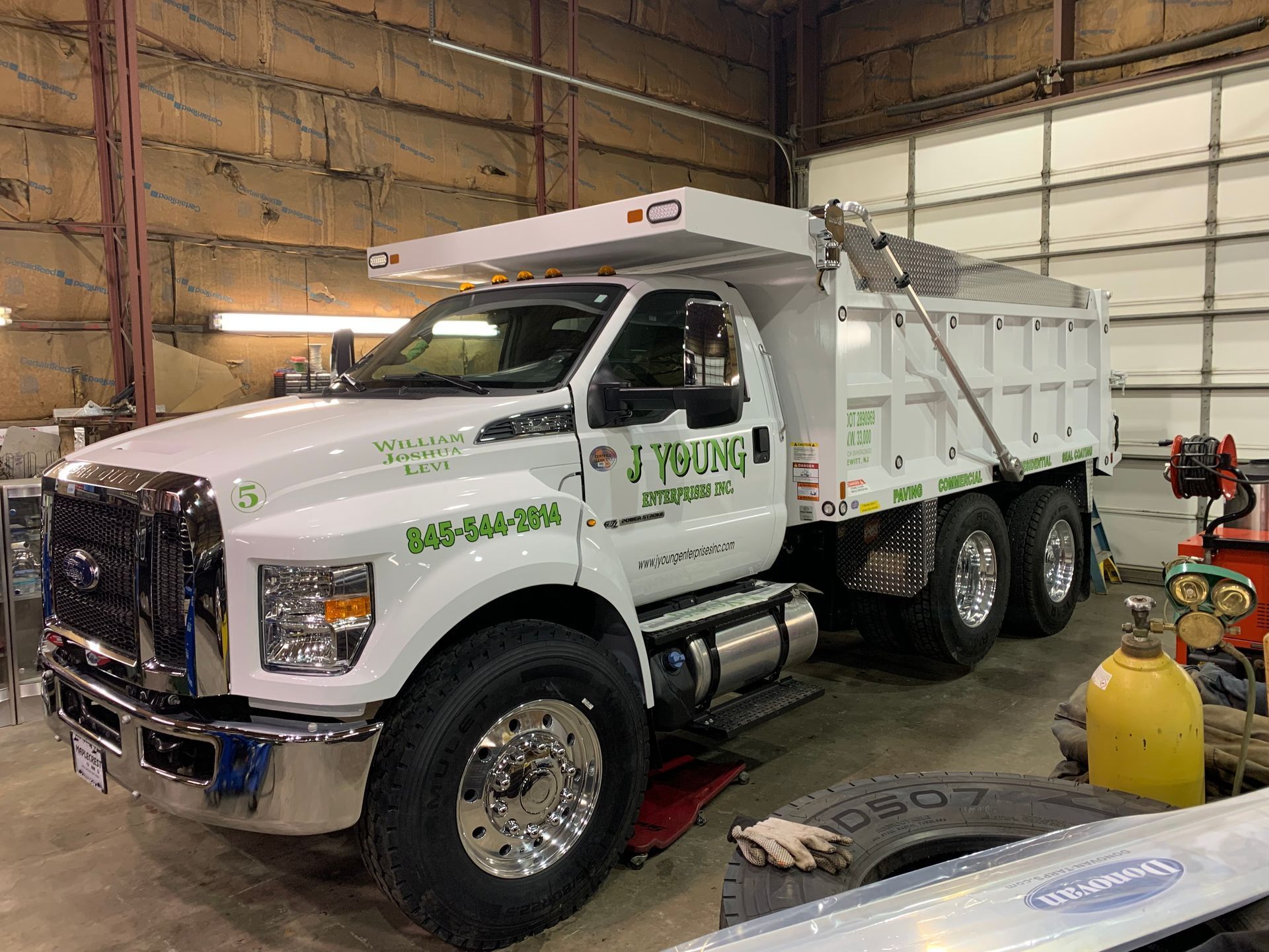 White dump truck in a garage; logo 