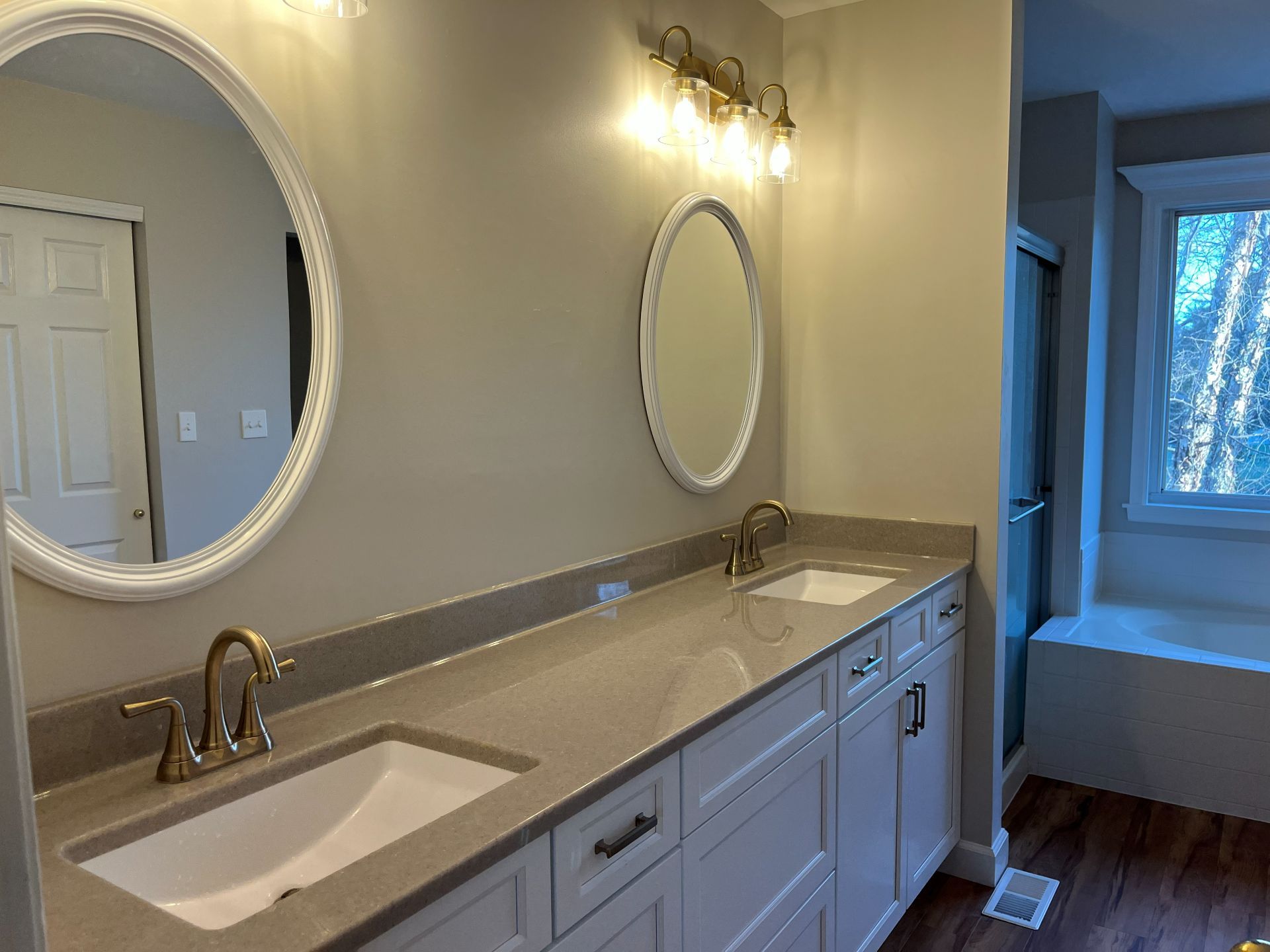 Modern bathroom vanity with double sinks, round mirrors, and soft wall lighting