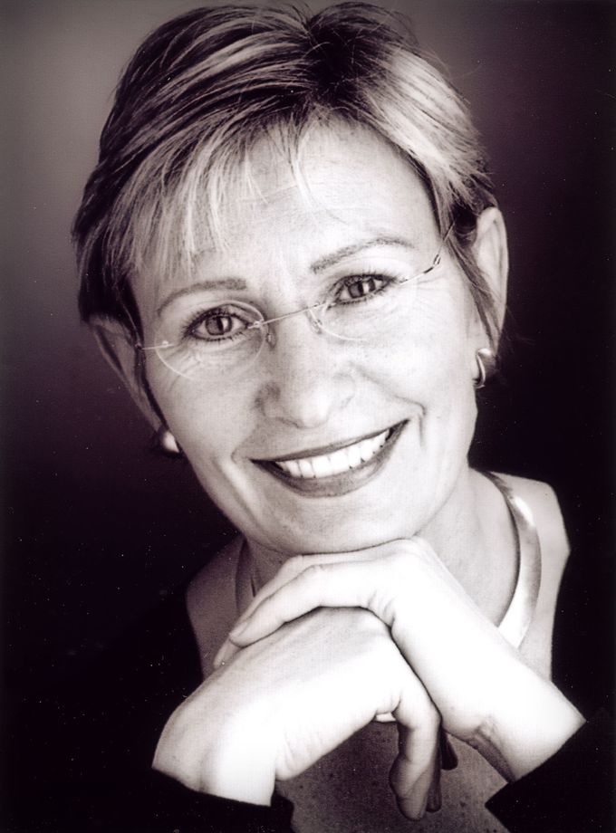 Ein Schwarzweißfoto einer lächelnden Frau mit Brille