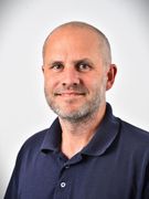 En smilende kardiolog i en marineblå polo-shirt