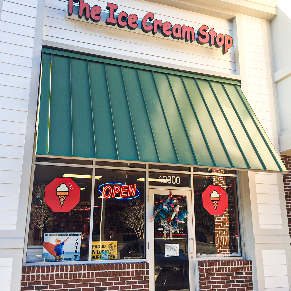 The ice cream shop has an open sign in front of it