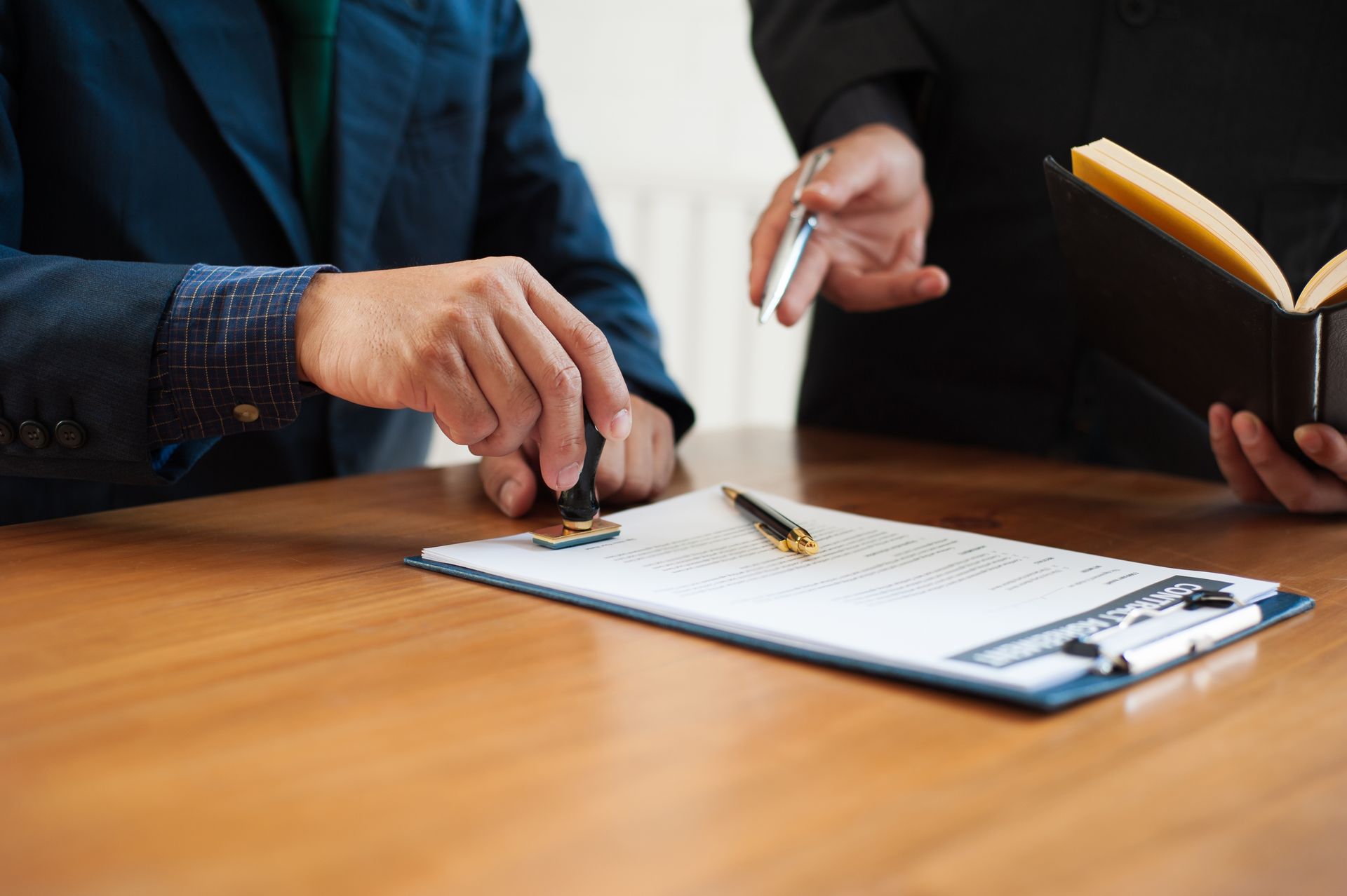 A lawyer or businessman is stamping on a contract document.