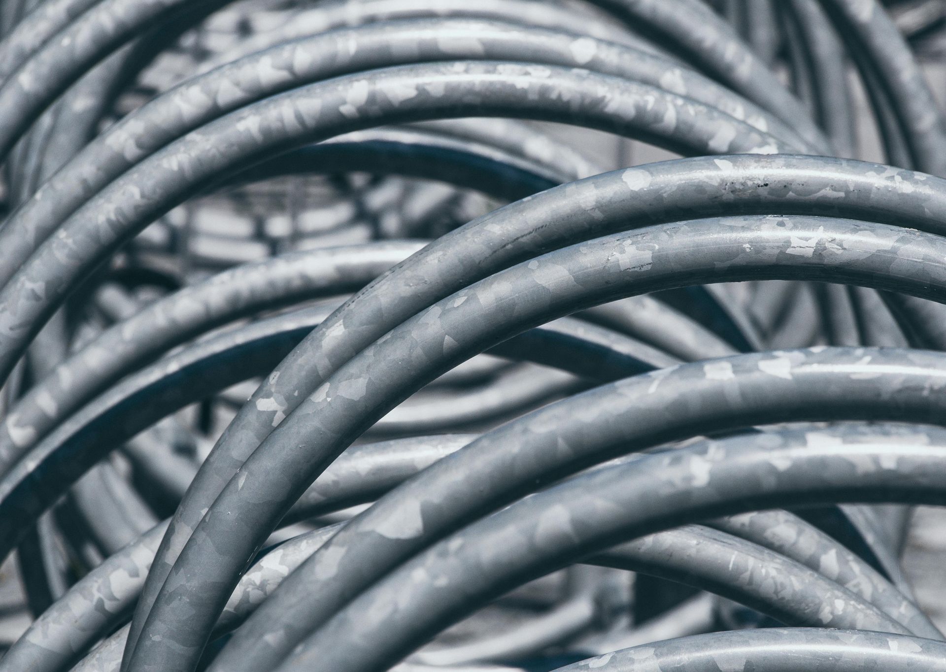Coiled gray metal cables stacked in a tangled pattern