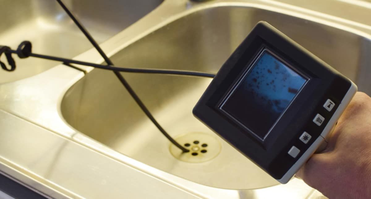 A Person is Holding a Camera Over a Sink — All Plumb & Gas in North Boambee Valley, NSW