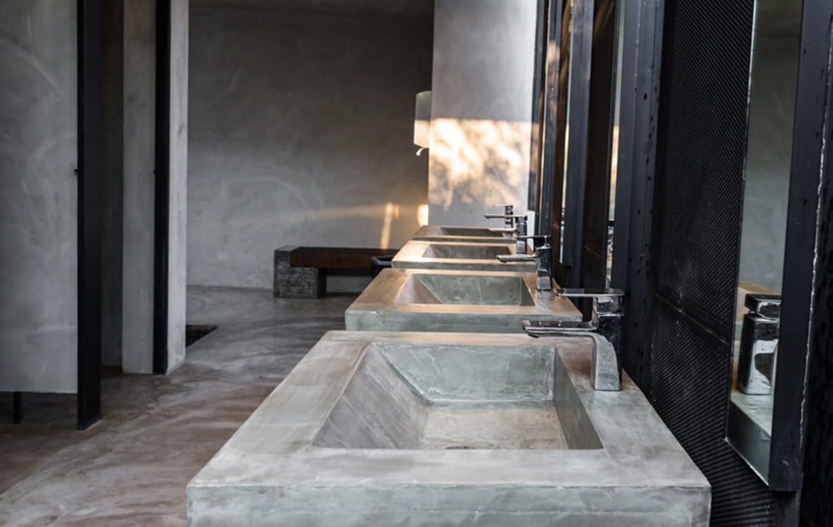 A Bathroom With a Row of Concrete Sinks and Mirrors — All Plumb & Gas in Billingen, NSW