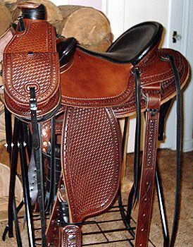 Brown leather western saddle with tooled details and a matching canteen.
