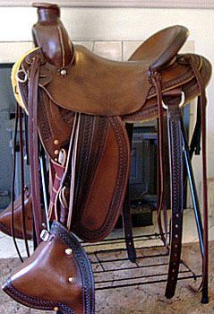 Brown leather western saddle on a metal stand.
