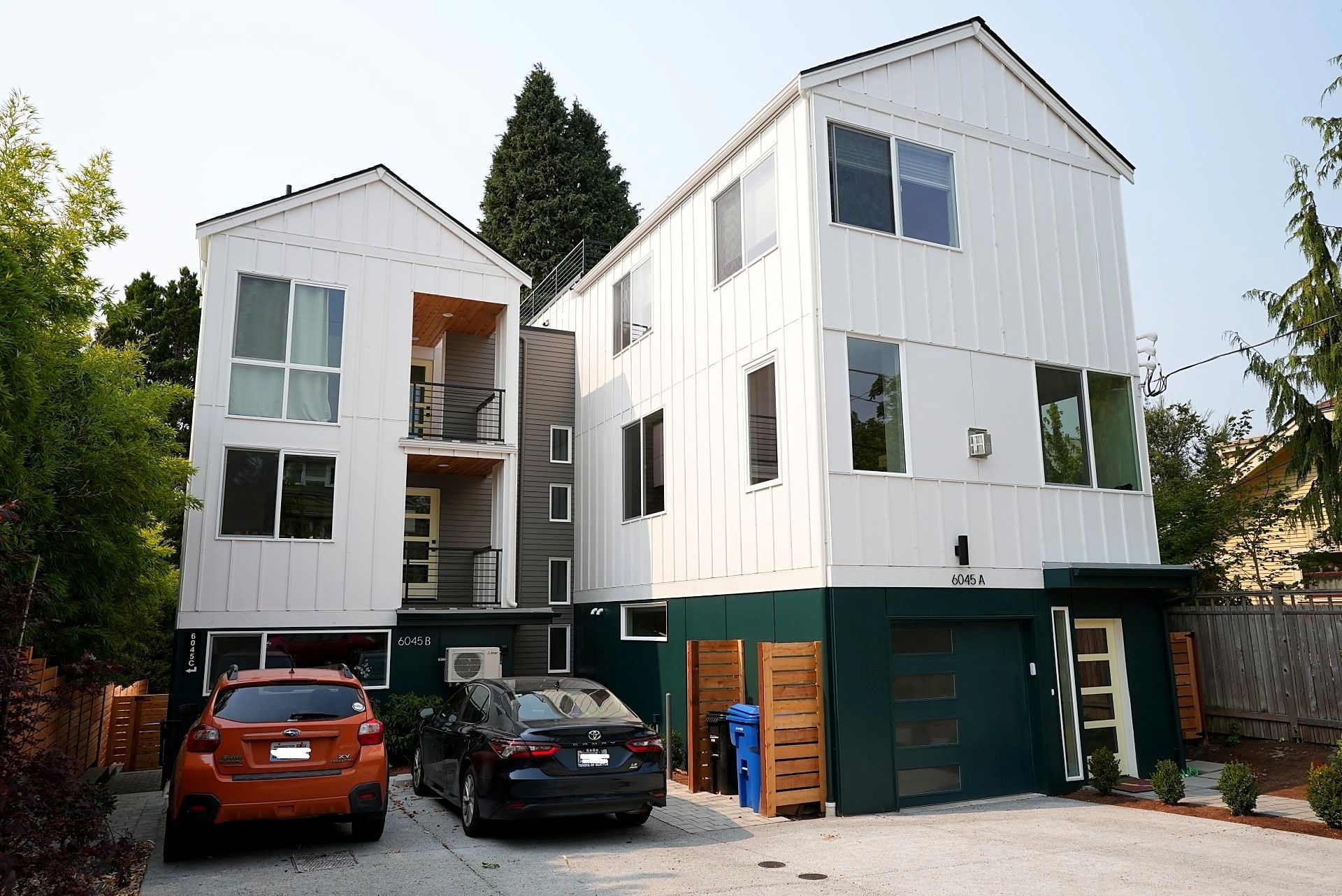 A white house with a green garage door and a yellow door