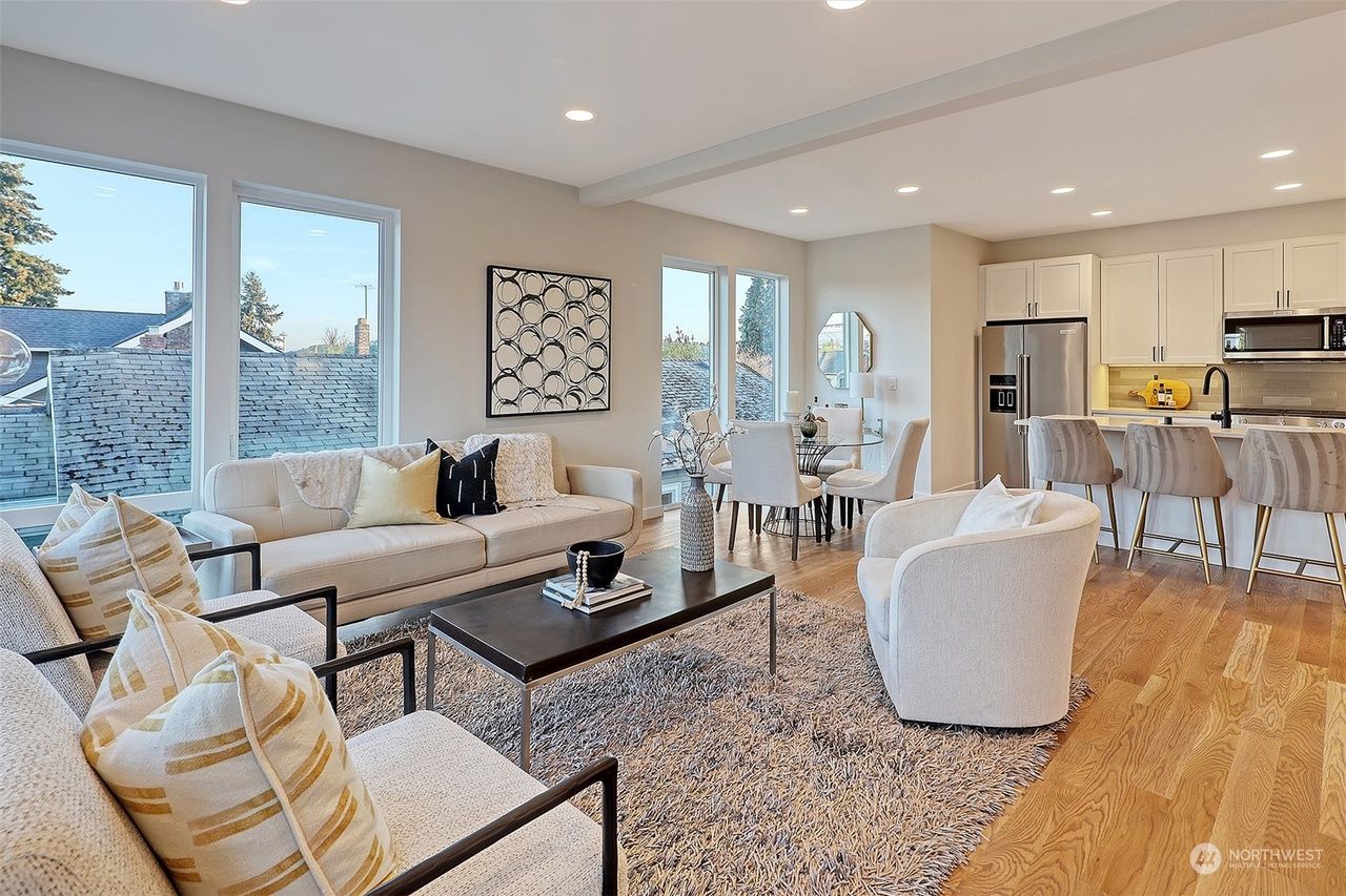 A living room with a couch , chairs , a coffee table and a rug.