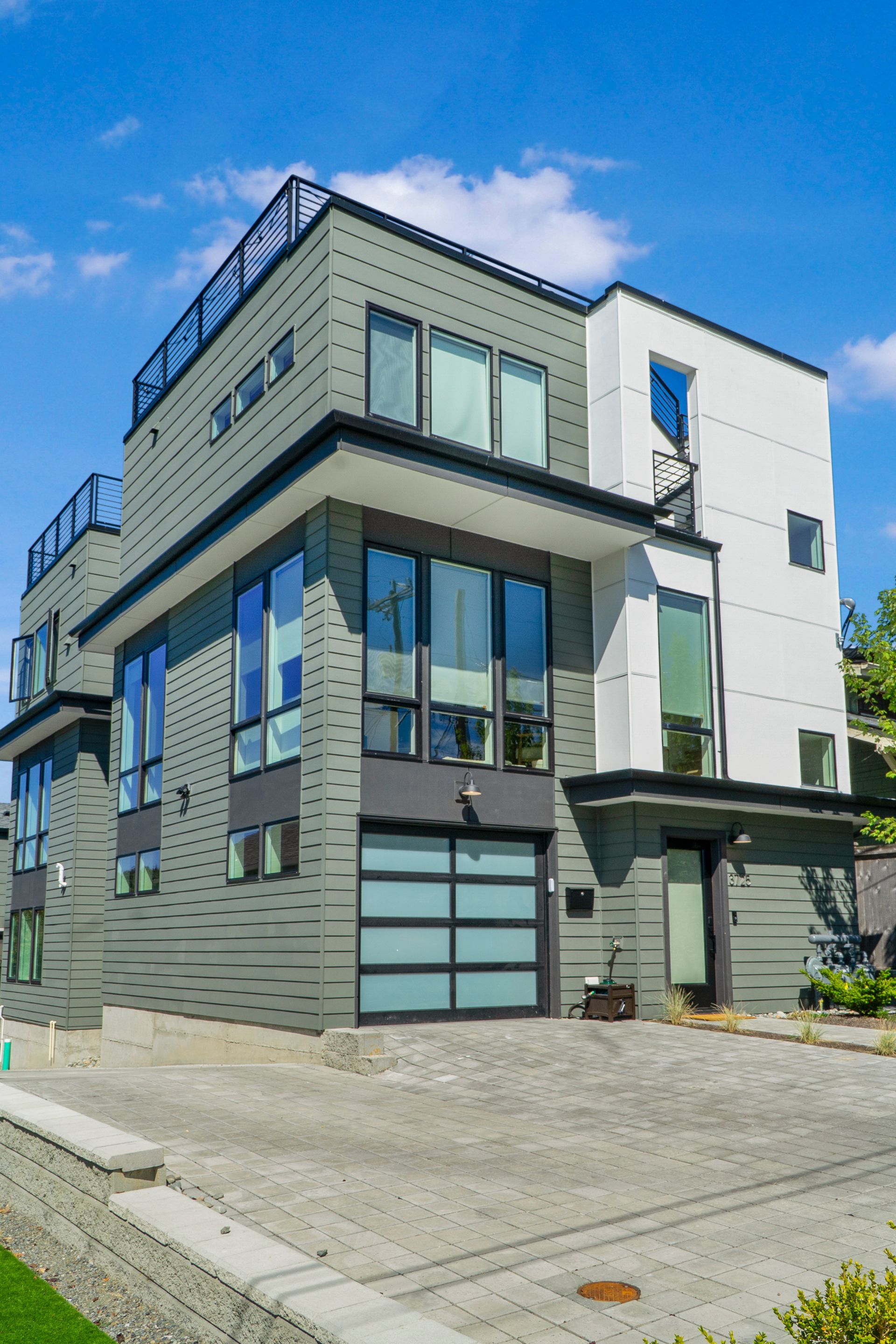 A large modern house with a lot of windows and a garage