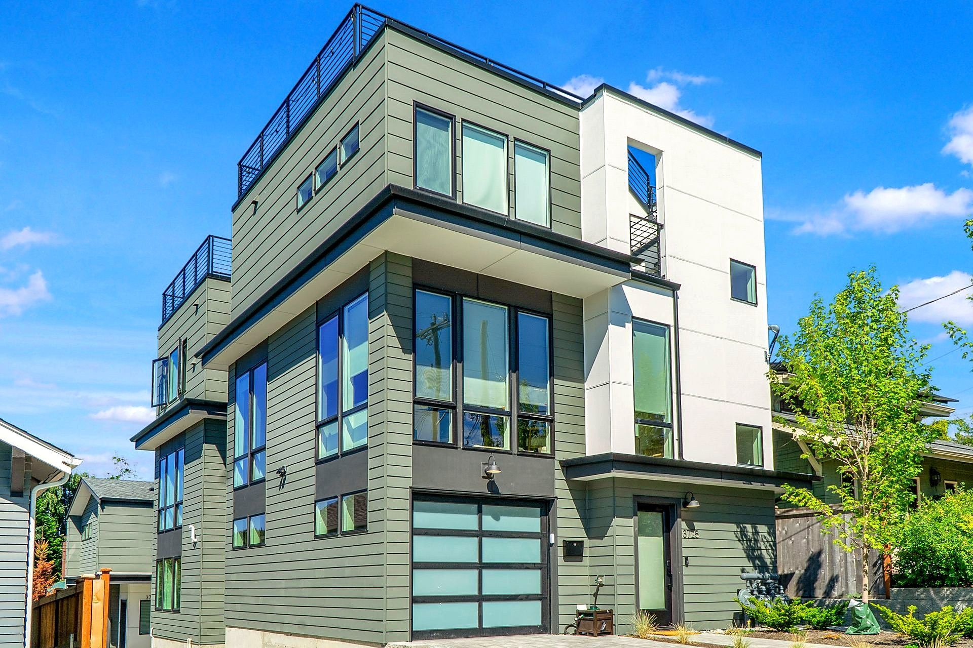 A large modern house with a lot of windows and a garage door.