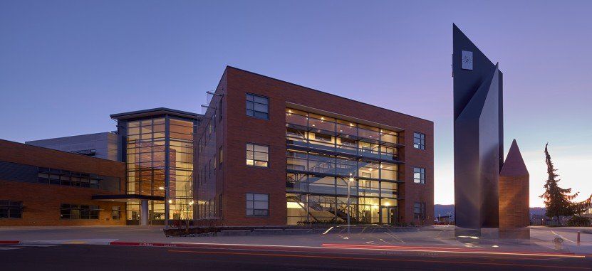 A large brick building with a lot of windows is lit up at night.