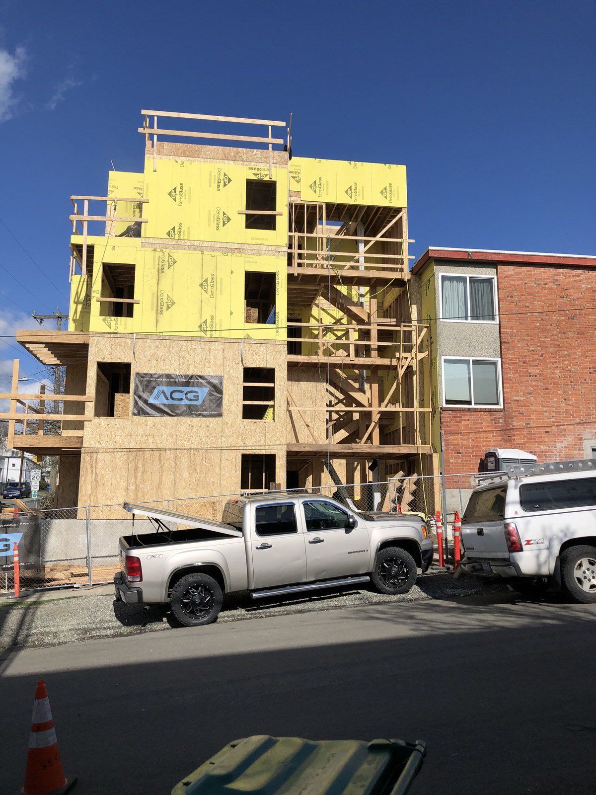 A truck is parked in front of a building under construction.