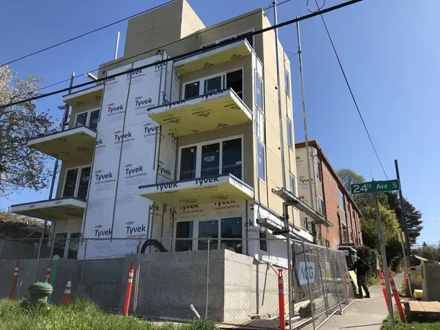 A building is being built with a lot of windows and balconies.
