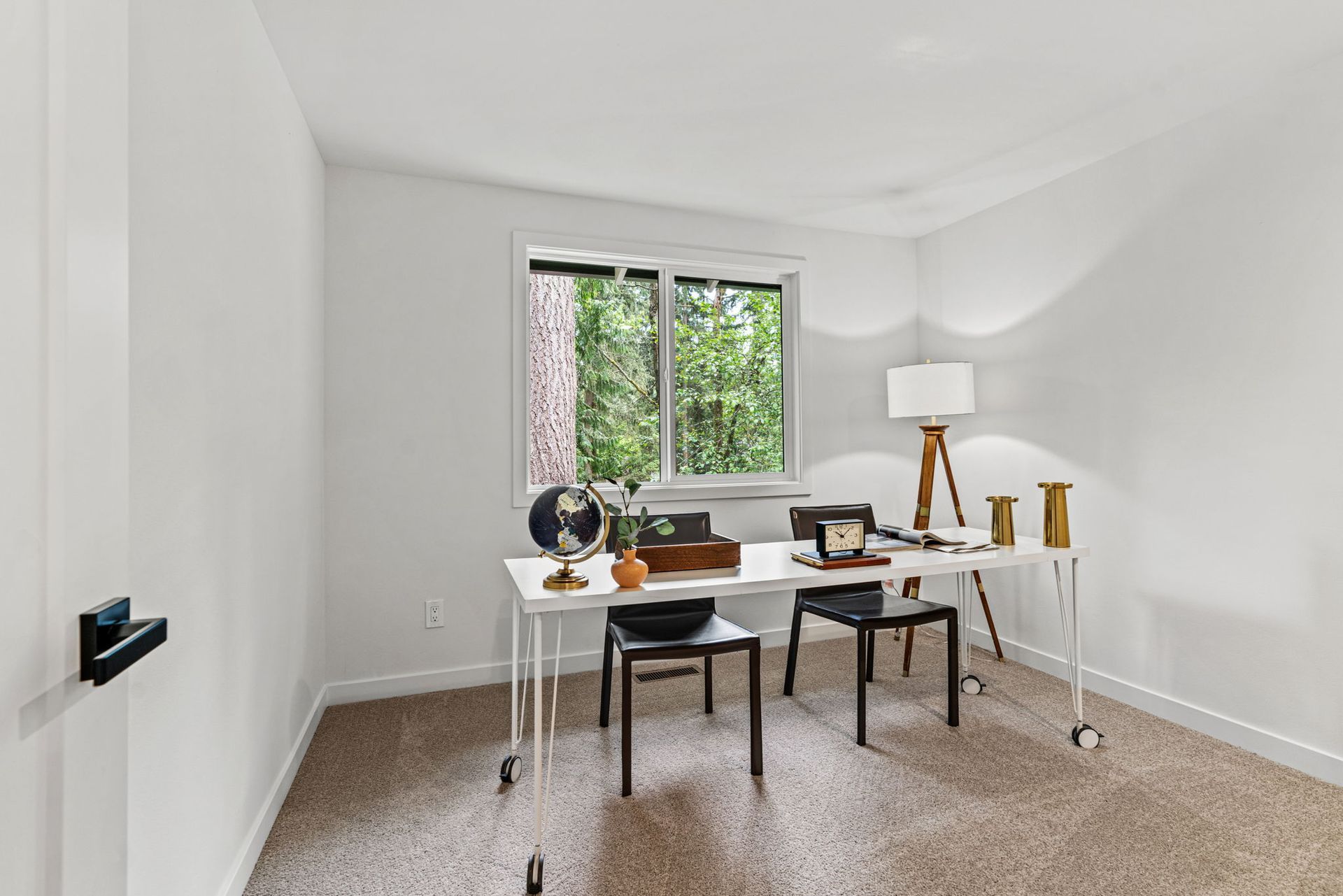 Minimal dining room with white walls, a window, a table, two chairs, and a floor lamp