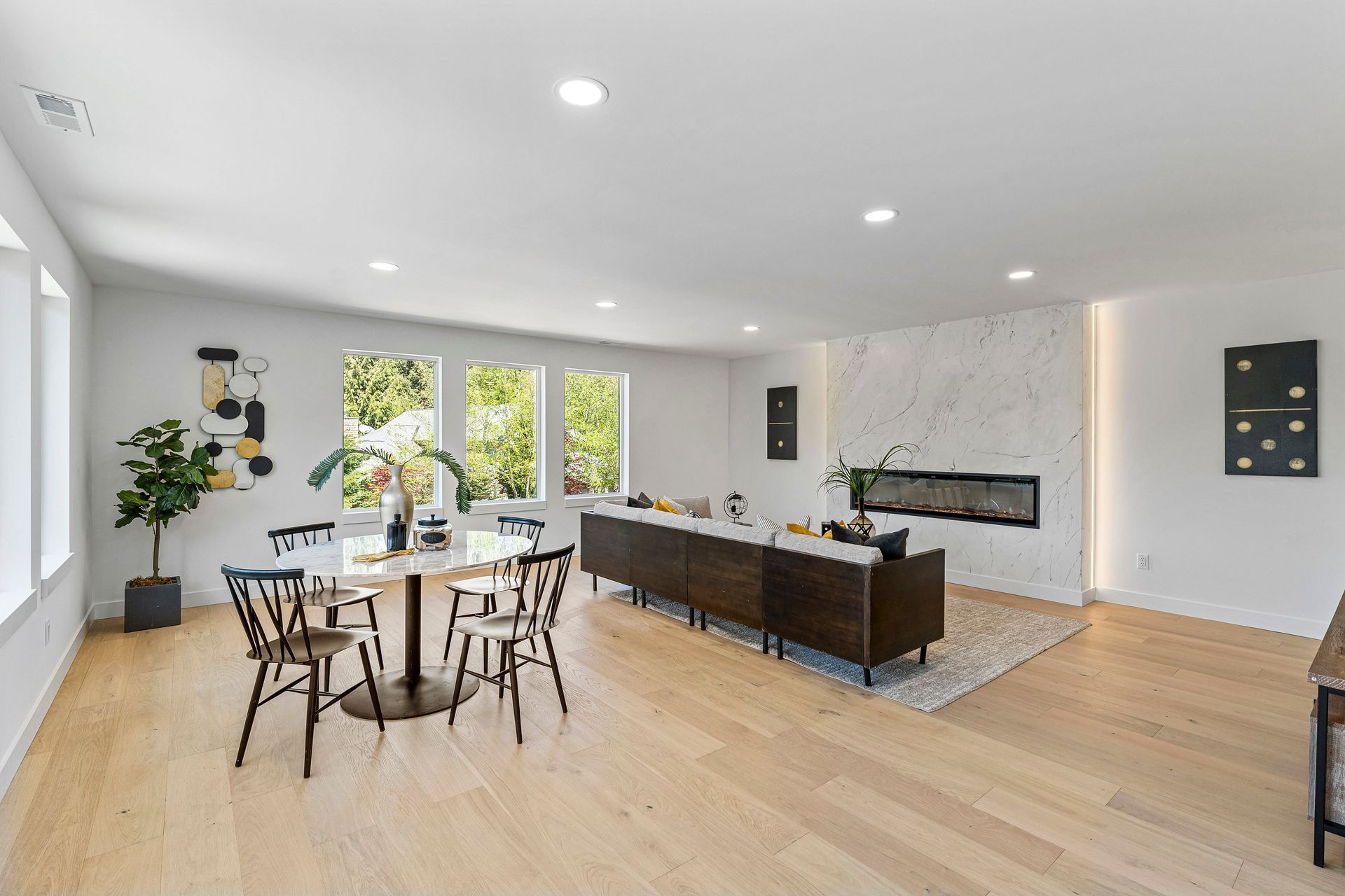 A living room with a dining table and chairs and a fireplace.