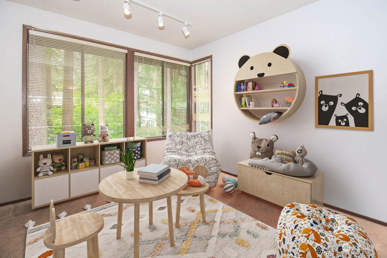 Playful kids’ room with window seat, round table, gray sofa, and panda-themed wall decor