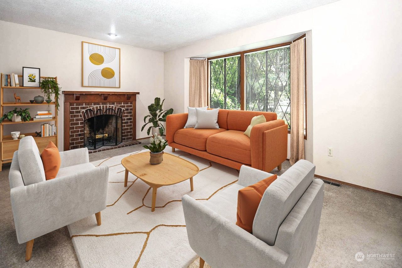 Bright living room with orange sofa, two gray chairs, fireplace, and large window with blinds