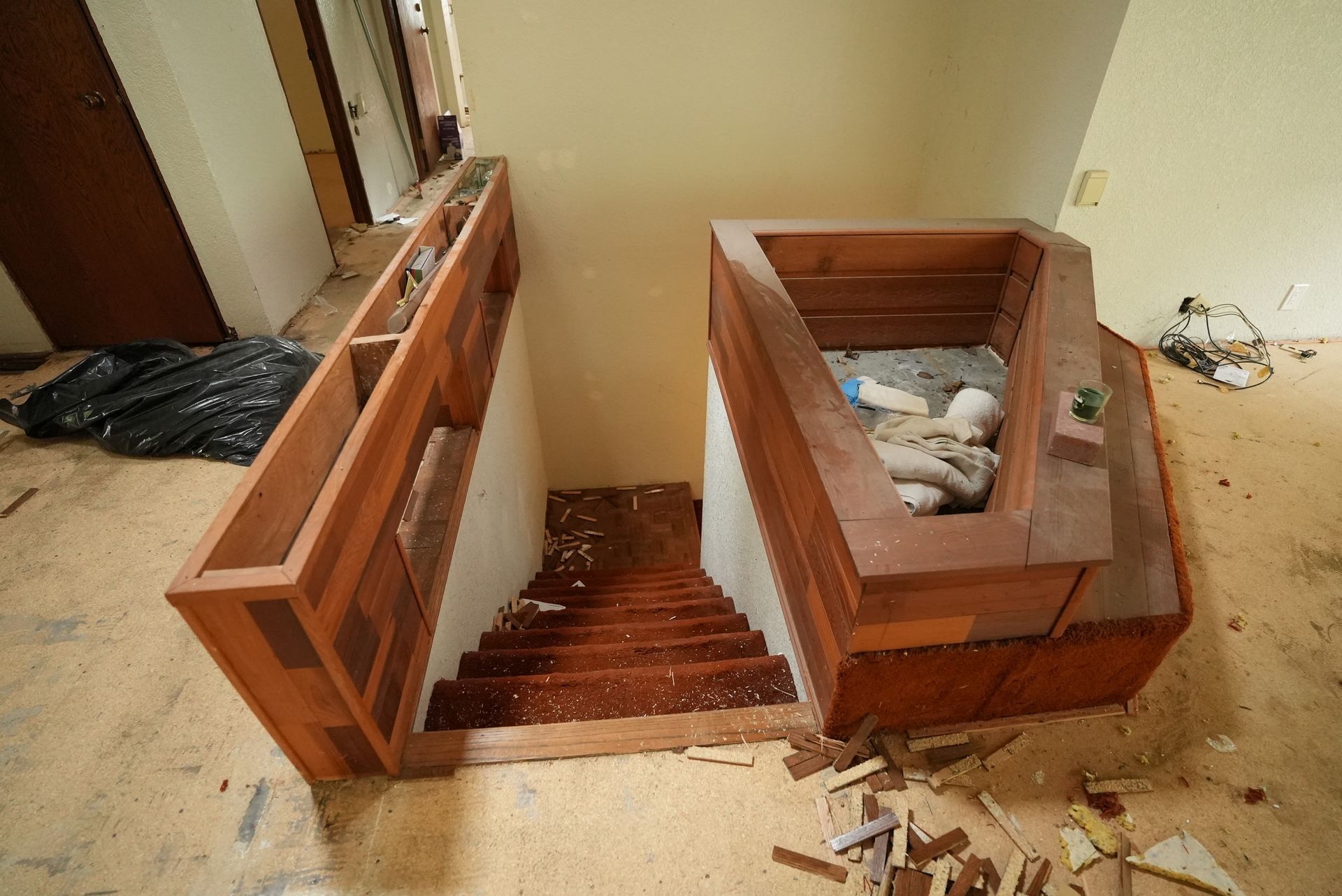 Broken wooden furniture and debris scattered across a damaged room floor.